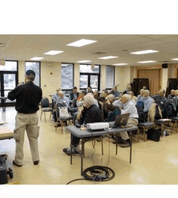A SAPFM chapter meeting in progress — presenter at front, members in folding chairs